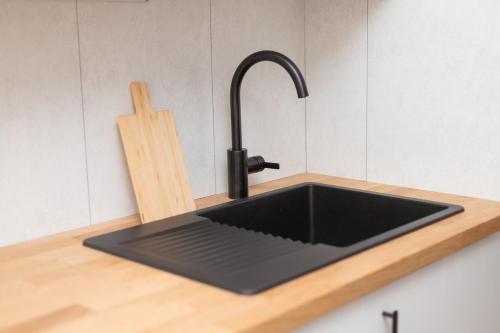 - un évier de cuisine avec un plan de travail noir dans l'établissement Appartement Messin 3 chambres - Le Terracotta, à Metz