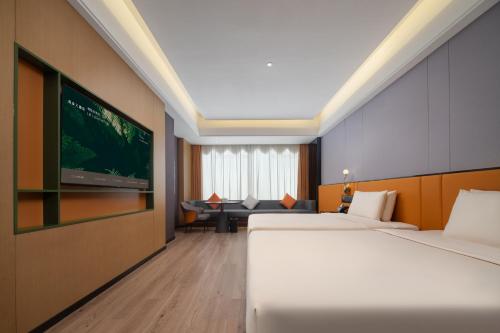 a hotel room with two beds and a flat screen tv at Atour X Hotel Xuefu Street Taiyuan South Railway Station in Taiyuan