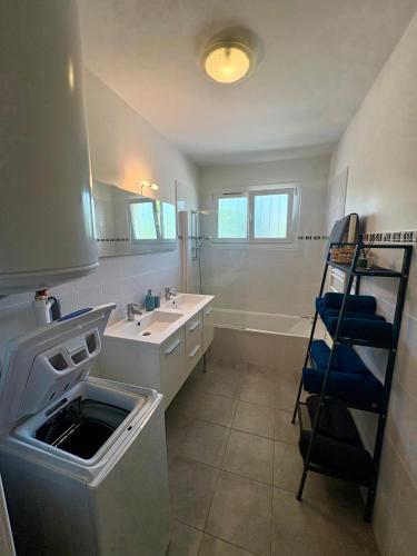 une salle de bain avec un lavabo et une baignoire dans l'établissement Superbe T3 refait à neuf avec vue mer, à Carqueiranne