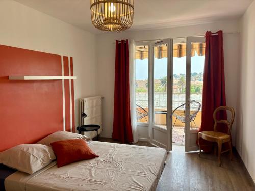 une chambre avec un lit et une vue sur un balcon dans l'établissement Superbe T3 refait à neuf avec vue mer, à Carqueiranne