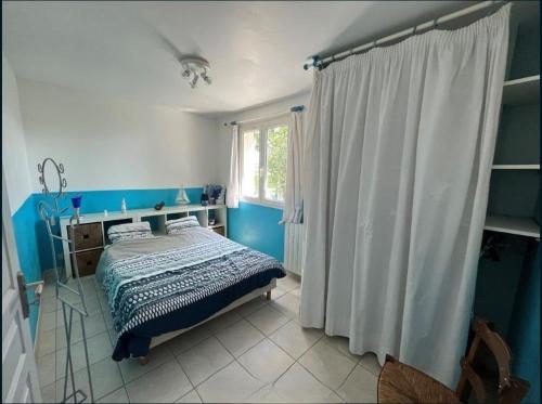 une chambre bleue avec un lit et une fenêtre dans l'établissement Villa au calme, jardin, piscine, jacuzzi, à Saussan