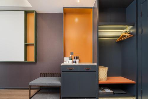 a kitchen with a bench and a refrigerator at Atour X Hotel Xuefu Street Taiyuan South Railway Station in Taiyuan