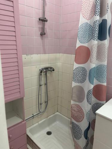 La salle de bains rose est pourvue d'une douche et d'une baignoire. dans l'établissement La Mascotte, à Nice