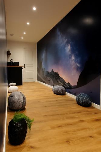 Cette chambre est ornée d'une fresque murale représentant les montagnes. dans l'établissement Nuit Dans les Étoiles - Spa Balnéo & Sauna Privé, à Troyes