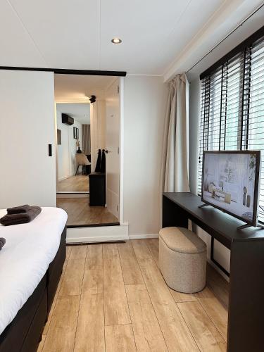 a bedroom with a bed and a desk and a mirror at Vakantiehuisje Noé in Gorinchem
