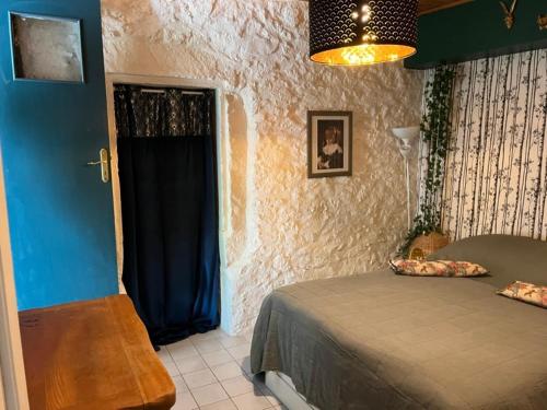 une chambre avec un lit et un mur bleu dans l'établissement Maison de caractère pour vacances ou travail, à Teyran