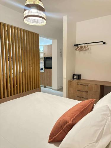 a bedroom with a large white bed and a light fixture at Ellie Apartments Stalida in Stalida