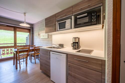 une cuisine avec un comptoir et une salle à manger dans l'établissement Studio 9 - La Palettaz, à Cohennoz
