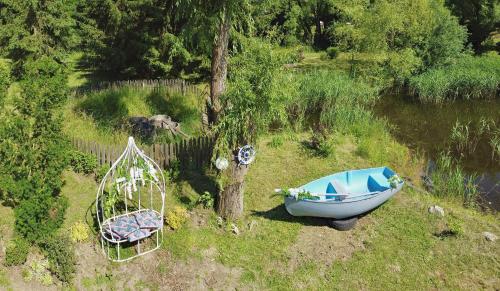a boat sitting in the grass next to a tree at Palócliget Vendégház in Kétbodony
