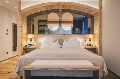 a bedroom with a large bed with a large mirror at Hotel Klosterbräu in Seefeld in Tirol