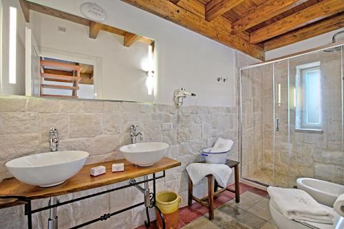 a bathroom with two sinks and a shower at Masseria Antoglia Exclusive Villa in Villa Castelli