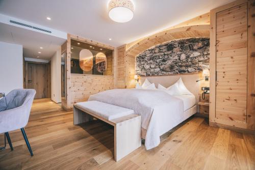 a bedroom with a white bed and a stone wall at Hotel Klosterbräu in Seefeld in Tirol
