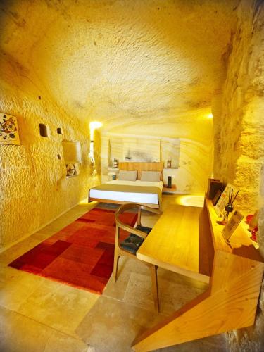 a bedroom with a bed and a couch in a room at Acropolis Cave Suite in Ürgüp