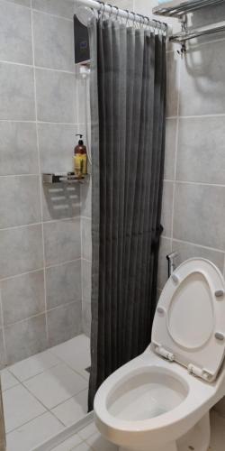 a bathroom with a shower curtain and a toilet at Quezon City Apartment 2 Condo-Hotel with Pool View in Manila