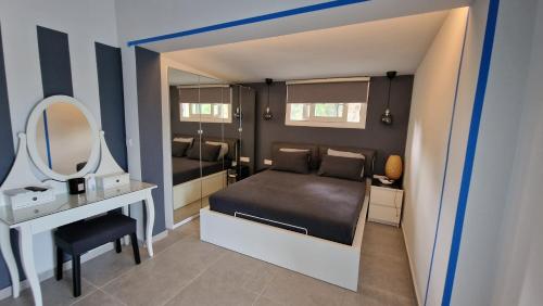 a small bedroom with a bed and a mirror at Anna Maria Mini Villa in Kriopigi