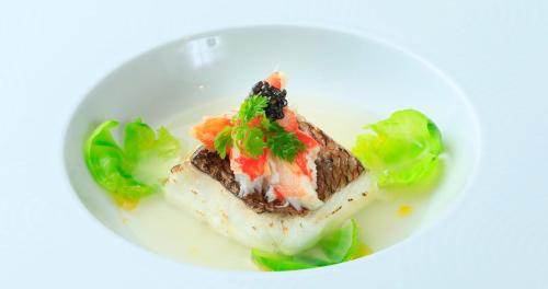 a white plate with a piece of fish with lettuce at Villa The Club 御殿場ウエスト in Gotemba