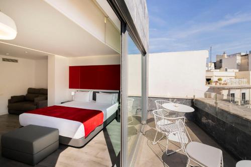 1 dormitorio con cama y sofá en el balcón en Eurostars Central, en Madrid