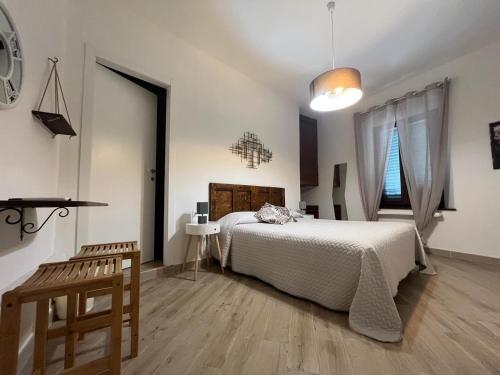 a white bedroom with a bed and a window at Tre Orologi Affittacamere in Piombino