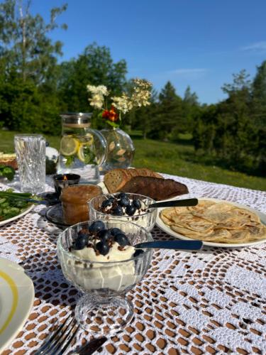 a table with plates and bowls of food on it at Muhu Kulla Saadu puhkemaja mere ääres in Raugi