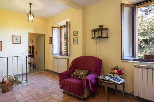 a living room with a chair and a table at Borgo Villa Certano - Case Vacanza in Toscana in Siena