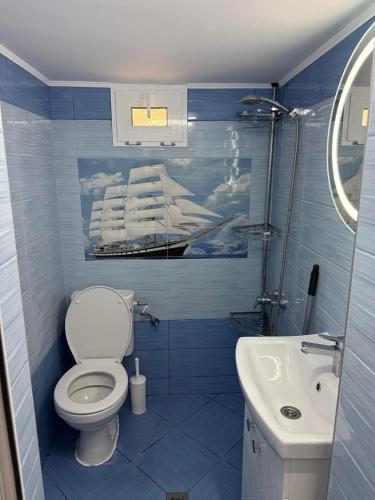 a blue bathroom with a toilet and a sink at Teo's house in Asprovalta