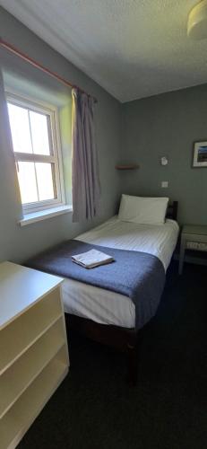 a small bedroom with a bed and a window at Oak Tree Cottage - 3 Bedroom in Louisburgh