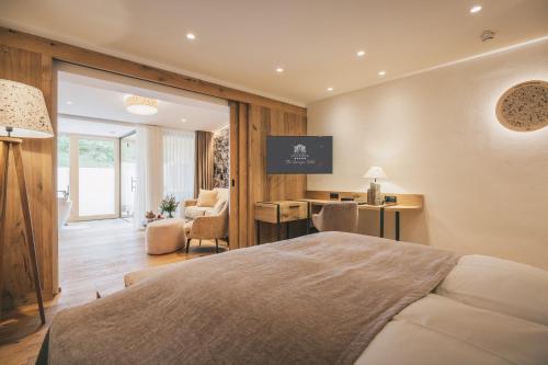 a bedroom with a bed and a desk with a computer at Hotel Klosterbräu in Seefeld in Tirol