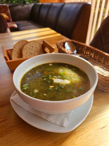 a bowl of soup sitting on a table with bread at Hotel resort Sedula in Skogalis