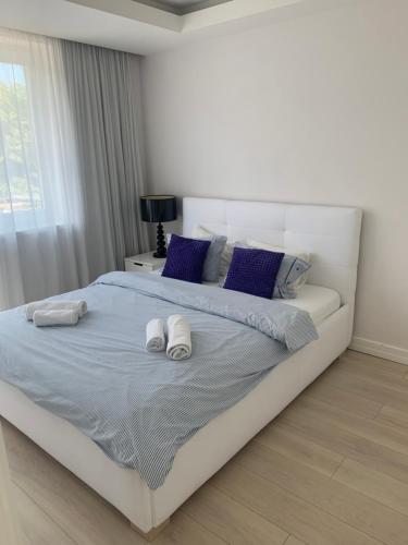 a bedroom with a large white bed with blue pillows at Apartament z balkonem in Sopot
