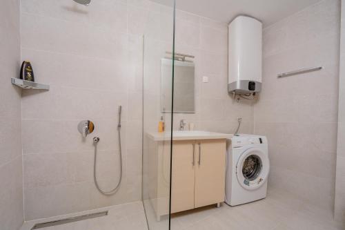 a bathroom with a washing machine and a shower at City Apartments 2 in Budva