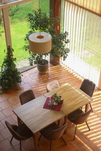 a wooden table and chairs in a room at Hotel resort Sedula in Skogalis