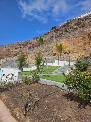 a park with palm trees and a mountain at Canaima 112 Puerto Rico in Puerto Rico de Gran Canaria