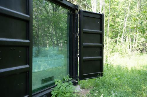 an open window of a house in the woods at Chic Sauna Cabin Near the Sea - MULIN Cabin Nº05 in Tsitre