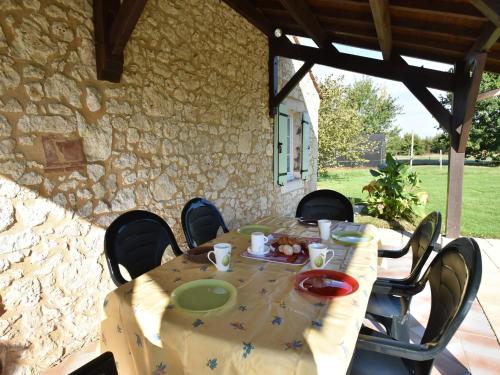 une table avec des chaises et un chiffon de table. dans l'établissement Spacious Holiday Home in Saint-Nexans with Terrace, à Saint-Nexans