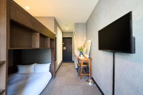 a hotel room with a bed and a flat screen tv at Sapporo - Apartment - Vacation STAY 29213v in Sapporo