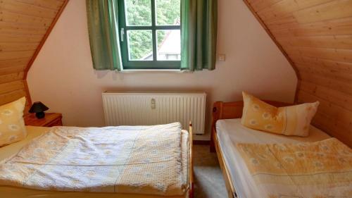 a bedroom with two beds and a window at Haus Heidi, Wellness und Ayurveda in Kurort Rathen