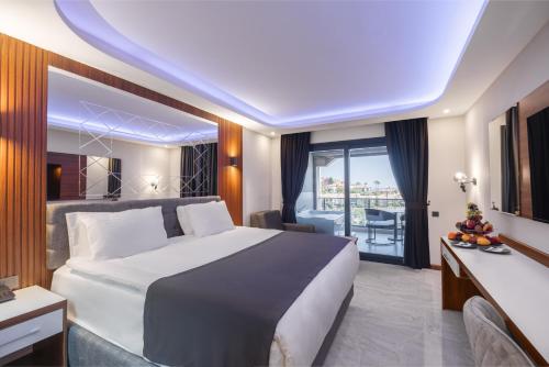 a hotel room with a large bed and a balcony at Club Robin Hood Hotel Adults Only in Alanya