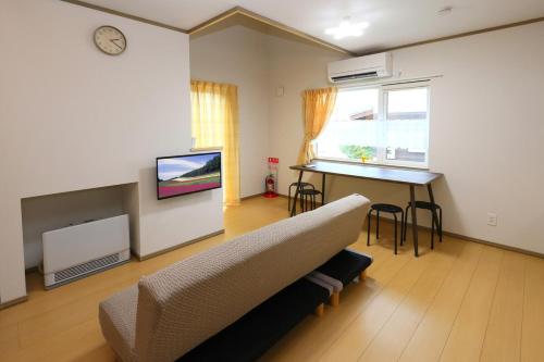 a living room with a couch and a table at Hill House B NakaFurano Hokkaido JAPAN in Nakafurano