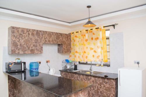 a kitchen with a sink and a microwave at Eldoten suites in Eldoret