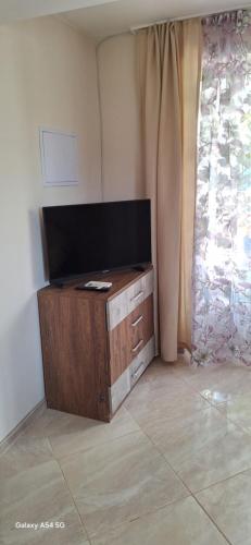 a living room with a flat screen tv and a window at Къща за гости ЕДЕЛВАЙС in Chernomorets