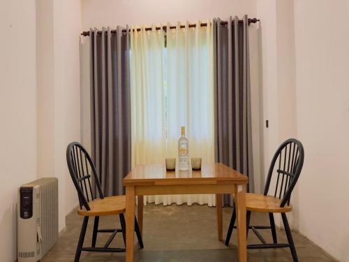una mesa con una botella de vino y dos sillas en Tarragon Leisure, en Matara