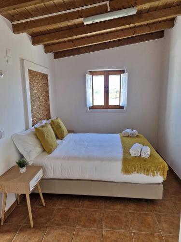 a bedroom with a large bed with two towels on it at Casa Amarela in Zambujeira do Mar