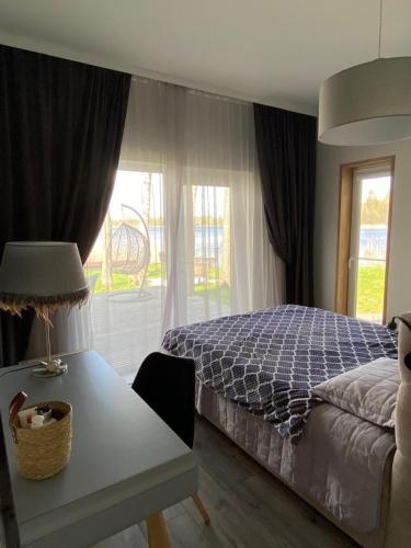 a bedroom with a bed and a table and a window at Mežmāja Spārītes in Geraņimova