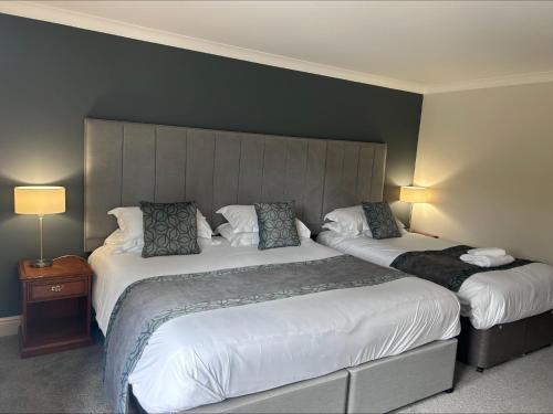 a hotel room with two beds and two lamps at Woodbury Park Hotel & Spa in Exeter