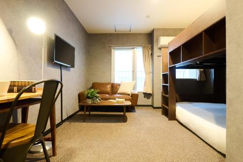 a hotel room with a bed and a couch and a table at Sapporo - Apartment - Vacation STAY 29227v in Sapporo