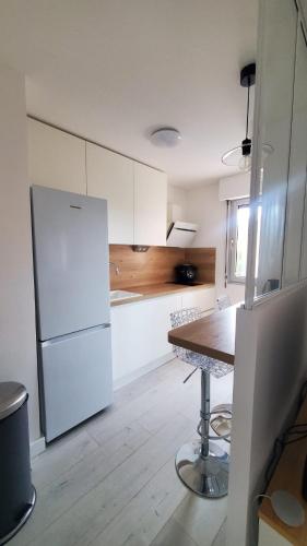 une cuisine blanche avec une table et un réfrigérateur dans l'établissement El Albaricoque - T2 Boutonnet, à Montpellier