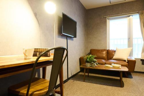 a living room with a couch and a table with a television at Sapporo - Apartment - Vacation STAY 29242v in Sapporo
