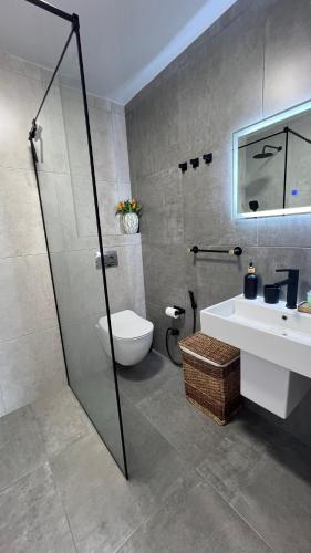 a bathroom with a shower and a toilet and a sink at Апартаменты с шикарным видом на море in Batumi