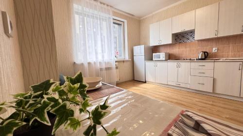 a kitchen with white cabinets and a potted plant at EmmaApart Comfort 169 in Astana