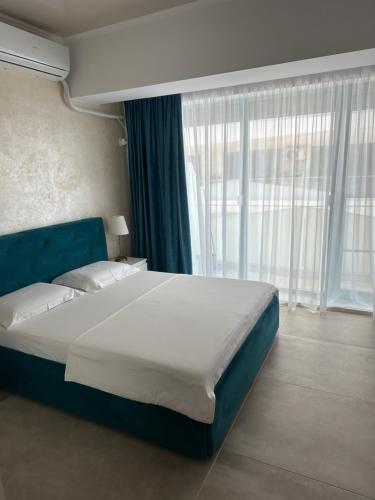 ein Schlafzimmer mit einem großen Bett und einem großen Fenster in der Unterkunft Zev-S10 in Mamaia Nord – Năvodari